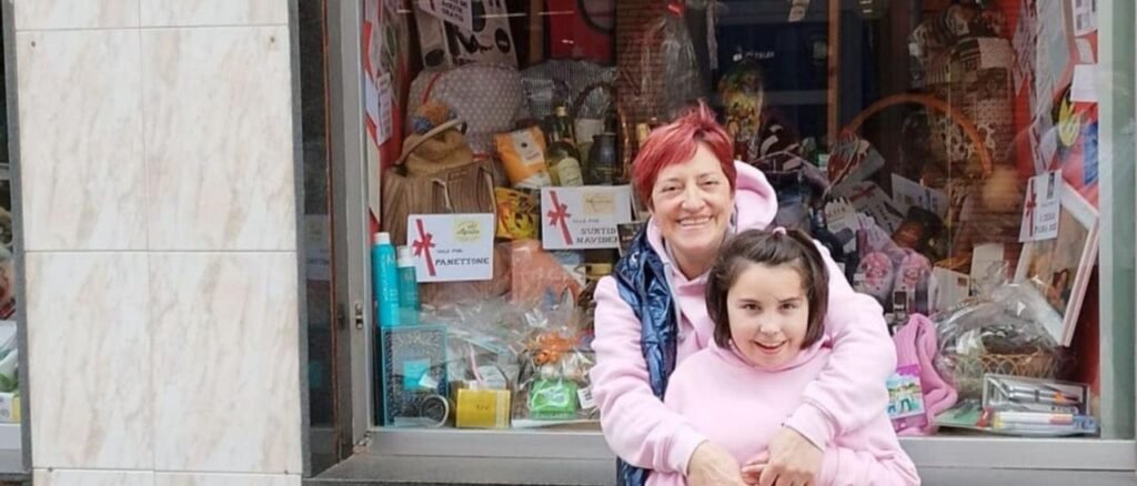 La pequeña Carmen Rodríguez, con su madre Luisa Fernández, ante uno de los establecimientos colaboradores en la iniciativa solidaria para recaudar fondos para la investigación de la enfermedad Bpan.